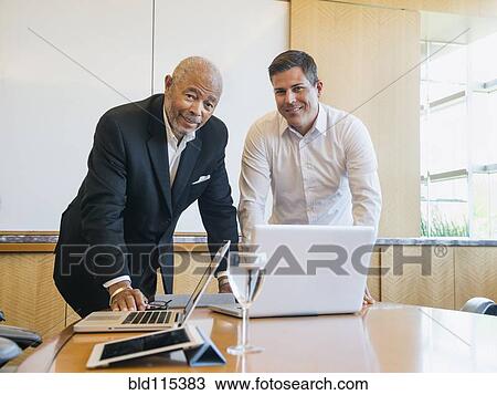Stock Image - Businessmen talking in meeting. Fotosearch