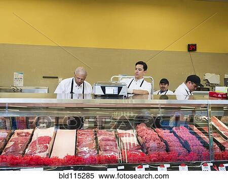 Stock Photography - Butchers at meat counter of grocery store. Fotosearch