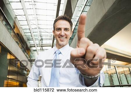 Stock Image - Caucasian businessman holding up finger. Fotosearch