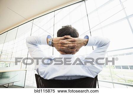 Stock Photography - Caucasian businessman relaxing at desk. Fotosearch