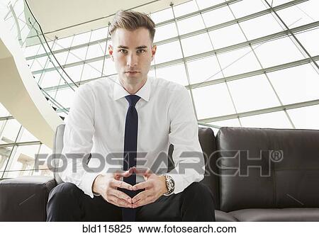 Caucasian businessman sitting on sofa in lobby View Large Photo Image Stock Photography - Caucasian businessman sitting on sofa in lobby. Fotosearch