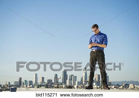 Caucasian businessman standing on urban rooftop View Large Photo Image Stock Image - Caucasian businessman standing on urban rooftop. Fotosearch