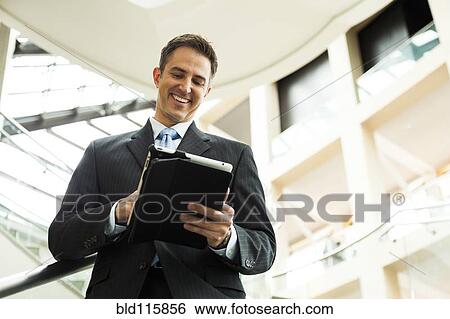 Caucasian businessman using digital tablet View Large Photo Image Stock Photograph - Caucasian businessman using digital tablet. Fotosearch