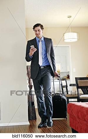 Caucasian businessman wheeling luggage View Large Photo Image Stock Image - Caucasian businessman wheeling luggage. Fotosearch