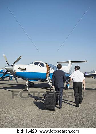 Stock Photo - Caucasian businessmen walking on runway. Fotosearch