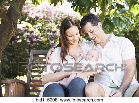 Caucasian couple holding baby outdoors View Large Photo Image Stock Photo - Caucasian couple holding baby outdoors. Fotosearch