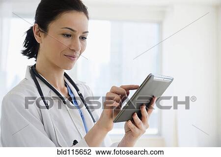 Stock Image - Caucasian doctor using tablet computer. Fotosearch