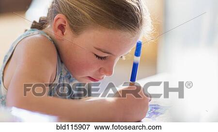 Stock Photo - Caucasian girl coloring at table. Fotosearch
