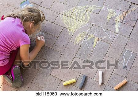 Stock Image - Caucasian girl drawing with chalk on brick. Fotosearch