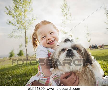 Caucasian girl hugging dog in grass View Large Photo Image Stock Photo - Caucasian girl hugging dog in grass. Fotosearch