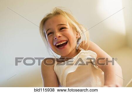 Stock Photo - Caucasian girl laughing indoors. Fotosearch