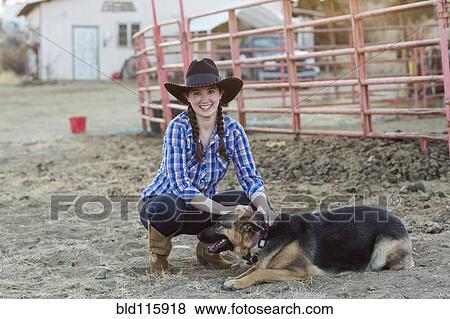 Stock Photo - Caucasian girl petting dog on farm. Fotosearch
