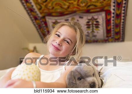 Picture - Caucasian girl smiling on sofa. Fotosearch