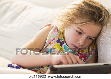 Caucasian girl using tablet computer on sofa View Large Photo Image Stock Image - Caucasian girl using tablet computer on sofa. Fotosearch