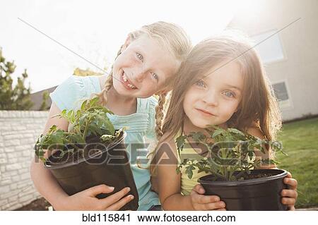 Stock Image - Caucasian girls gardening together. Fotosearch