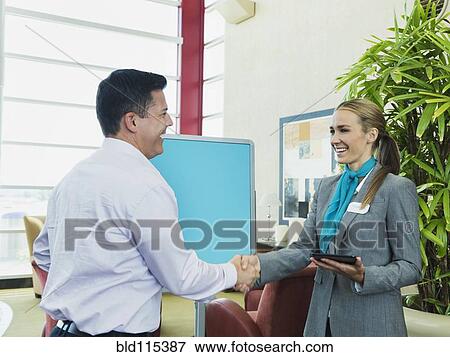 Caucasian hostess greeting businessman View Large Photo Image Stock Photo - Caucasian hostess greeting businessman. Fotosearch