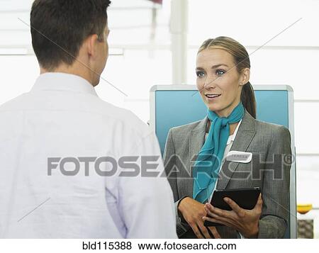 Stock Photo - Caucasian hostess talking to businessman. Fotosearch