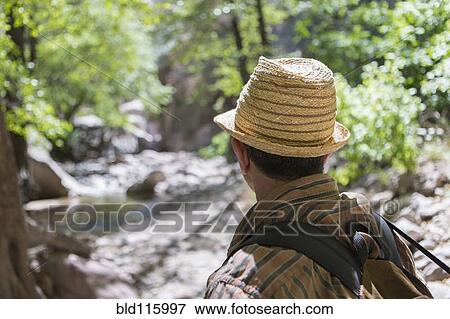 Stock Photo - Caucasian man hiking in forest. Fotosearch