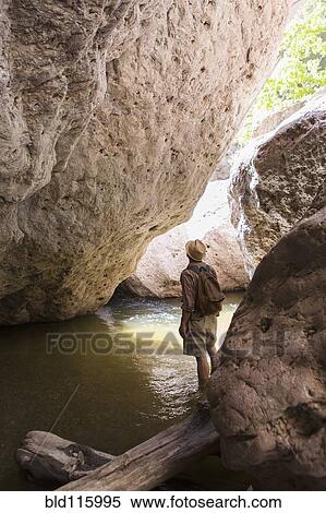 Caucasian man looking up at rock formation View Large Photo Image Stock Photography - Caucasian man looking up at rock formation. Fotosearch
