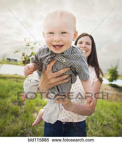 Stock Photography - Caucasian mother and baby playing outdoors. Fotosearch