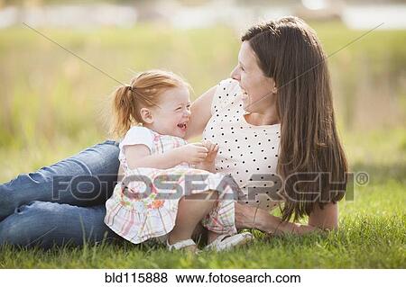 Caucasian mother and baby relaxing in grass View Large Photo Image Stock Photo - Caucasian mother and baby relaxing in grass. Fotosearch