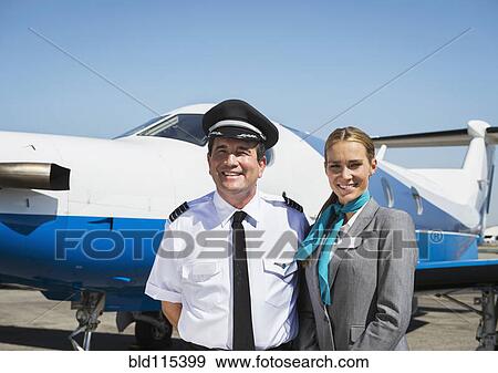 Caucasian pilot and flight attendant smiling on runway View Large Photo Image Stock Photo - Caucasian pilot and flight attendant smiling on runway. Fotosearch