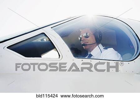 Picture - Caucasian pilot in airplane cockpit. Fotosearch