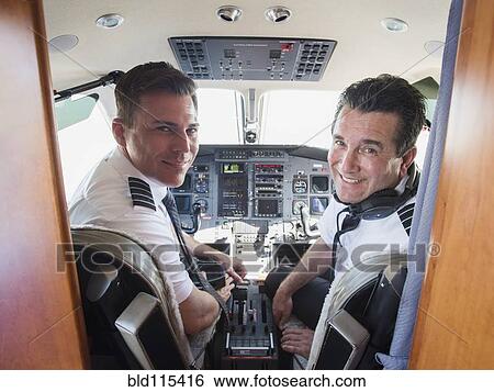 Stock Photograph - Caucasian pilots in airplane cockpit. Fotosearch