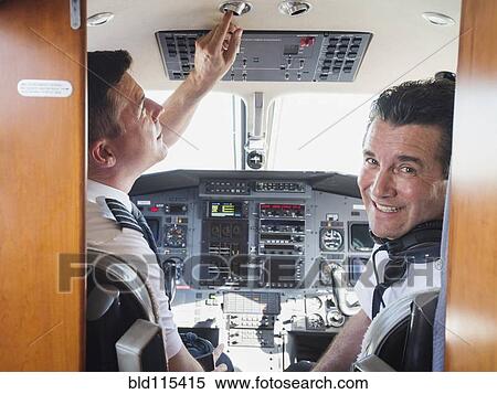 Stock Photography - Caucasian pilots in airplane cockpit. Fotosearch