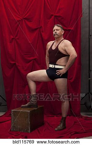 Caucasian weight lifter posing by curtain View Large Photo Image Stock Photo - Caucasian weight lifter posing by curtain. Fotosearch