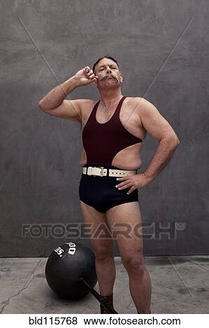 Stock Photo - Caucasian weight lifter twirling his mustache. Fotosearch
