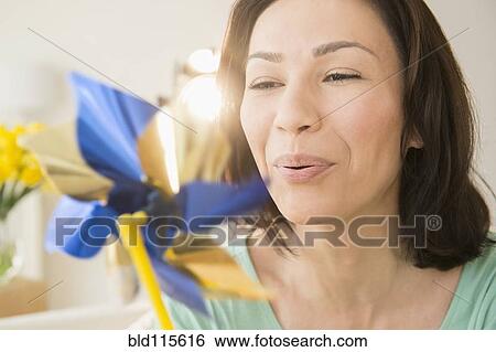Stock Photograph - Caucasian woman blowing pinwheel. Fotosearch