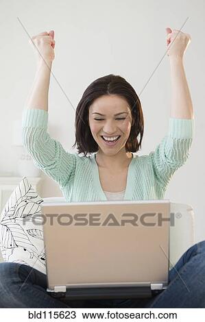 Caucasian woman cheering at laptop View Large Photo Image Stock Image - Caucasian woman cheering at laptop. Fotosearch