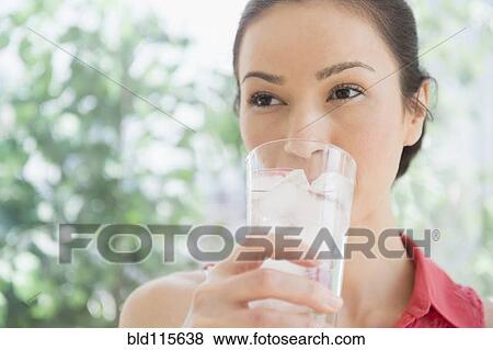 Stock Photo - Caucasian woman drinking glass of water. Fotosearch