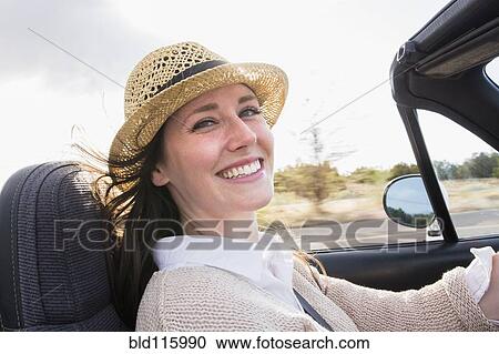 Stock Image - Caucasian woman driving convertible. Fotosearch