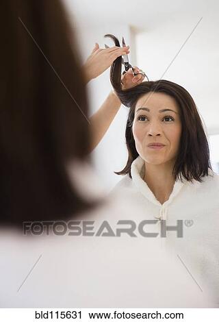 Stock Image - Caucasian woman having hair cut in salon. Fotosearch