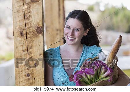 Caucasian woman holding basket of groceries View Large Photo Image Picture - Caucasian woman holding basket of groceries. Fotosearch