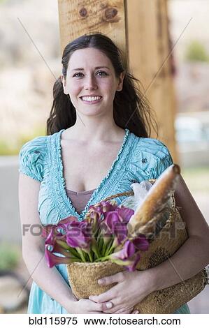 Stock Photography - Caucasian woman holding basket of groceries. Fotosearch