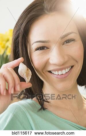 Stock Photo - Caucasian woman holding seashell. Fotosearch