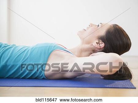 Caucasian woman laying on yoga mat View Large Photo Image Stock Photo - Caucasian woman laying on yoga mat. Fotosearch