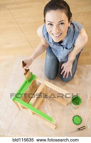 Stock Photography - Caucasian woman painting stool. Fotosearch