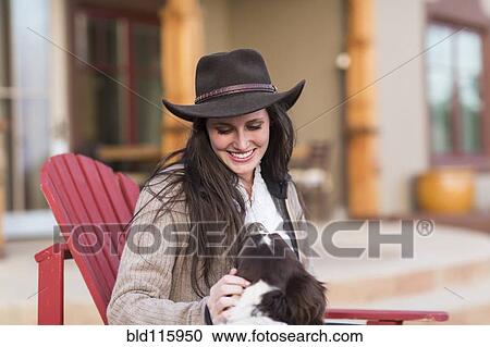 Caucasian woman petting dog in armchair View Large Photo Image Stock Image - Caucasian woman petting dog in armchair. Fotosearch