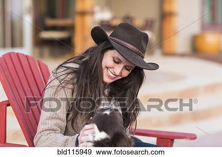 Caucasian woman petting dog in armchair View Large Photo Image Stock Photo - Caucasian woman petting dog in armchair. Fotosearch