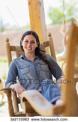 Stock Image - Caucasian woman relaxing in rocking chair. Fotosearch