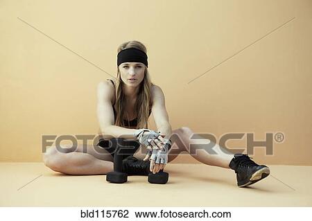 Stock Image - Caucasian woman resting during workout. Fotosearch
