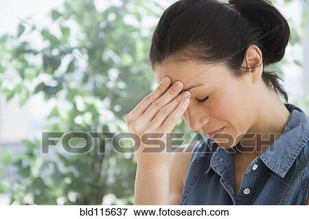Caucasian woman rubbing her forehead View Large Photo Image Stock Photo - Caucasian woman rubbing her forehead. Fotosearch