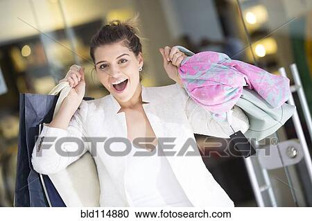 Stock Image - Caucasian woman shopping in mall. Fotosearch