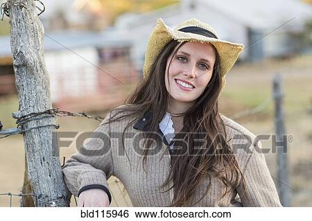 Caucasian woman smiling by barbed wire fence View Large Photo Image Stock Photograph - Caucasian woman smiling by barbed wire fence. Fotosearch