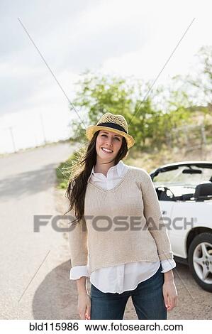 Stock Photograph - Caucasian woman smiling by convertible. Fotosearch