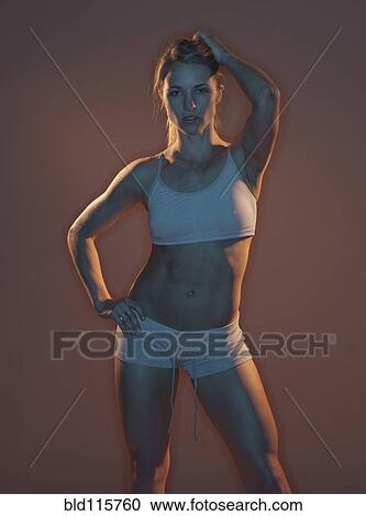 Stock Image - Caucasian woman wearing sports bra and shorts. Fotosearch